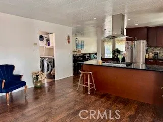 a living room with furniture a rug and kitchen view