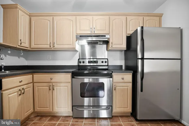 a kitchen with appliances a refrigerator and cabinets