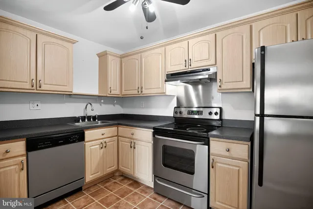 a kitchen with cabinets stainless steel appliances and a counter space