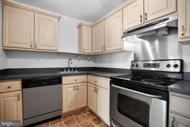 a kitchen with white cabinets and black appliances