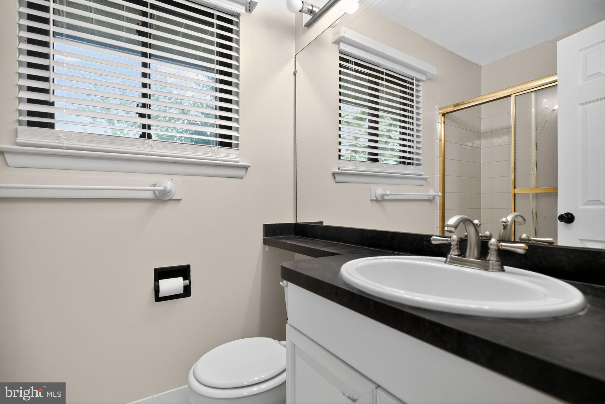 356 B Saybrook Lane, Unit B Wallingford, PA 19086 - Photo 21 of 34 a bathroom with a sink a toilet and a mirror