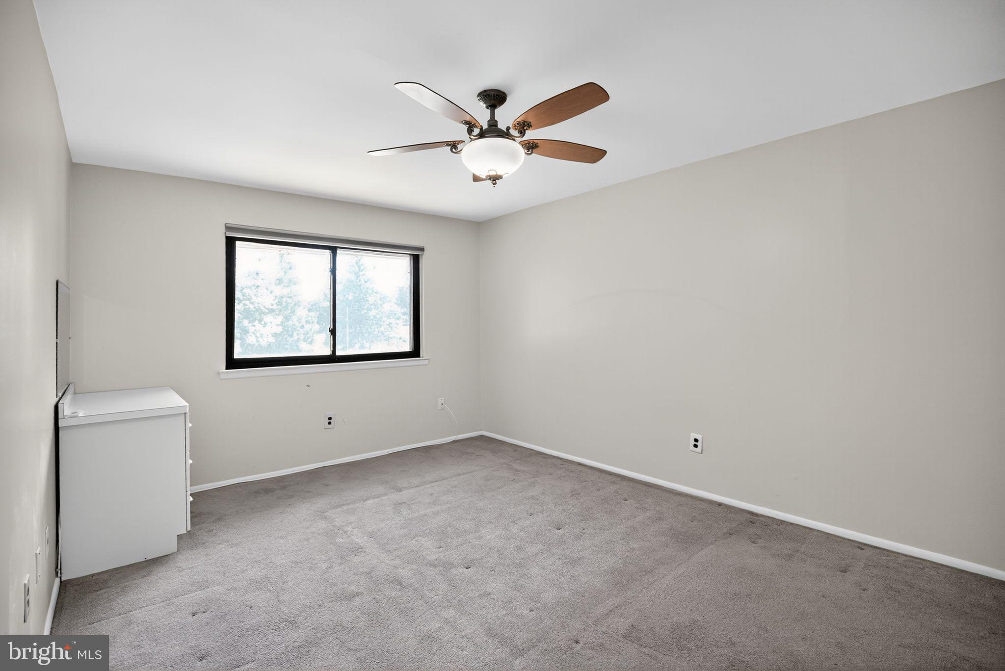 356 B Saybrook Lane, Unit B Wallingford, PA 19086 - Photo 22 of 34 a view of an empty room with a ceiling fan and a window