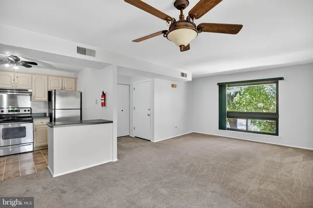 a view of kitchen with stainless steel appliances refrigerator oven and cabinets