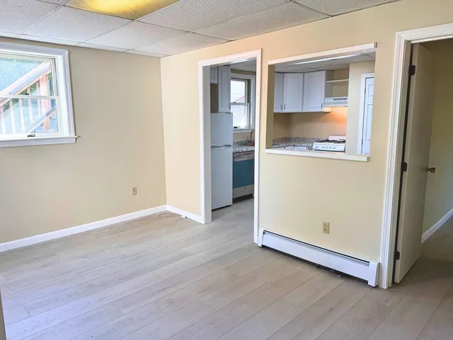 an empty room with wooden floor and cabinet