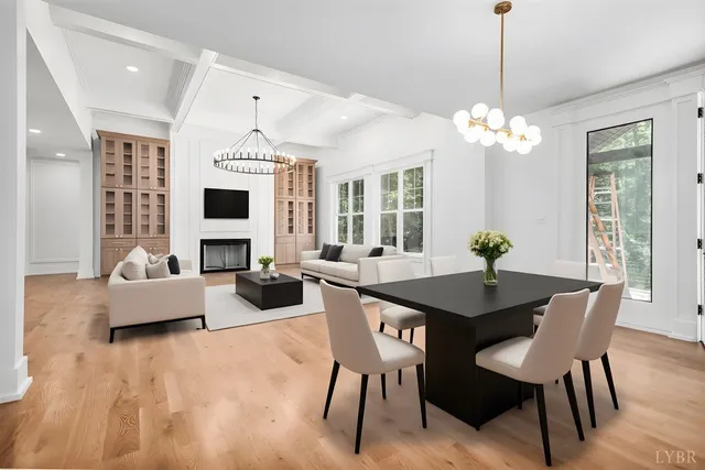 a view of a livingroom with a fireplace a chandelier and wooden floor