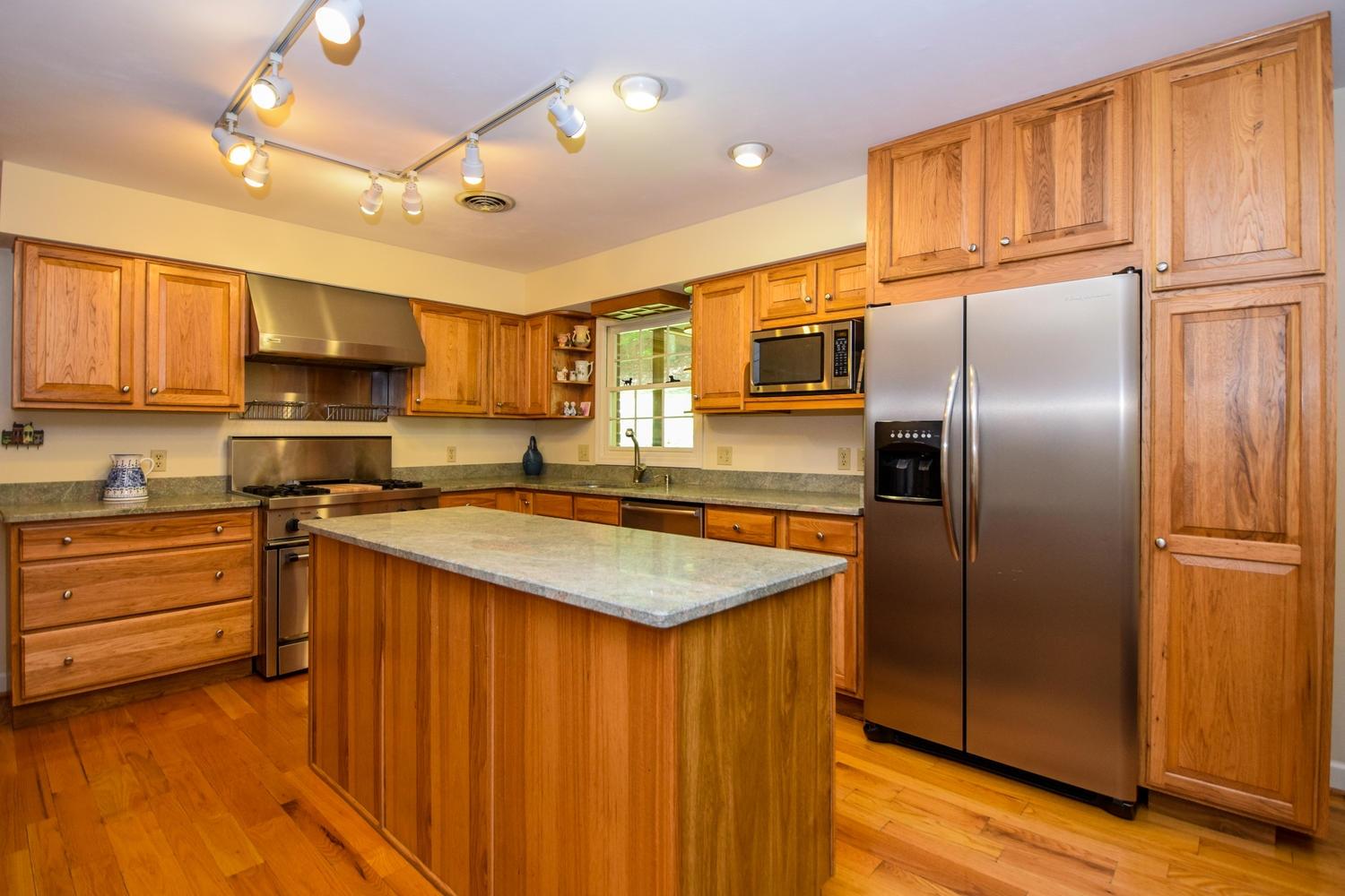 4848 Deerfield Road Southwest Roanoke, VA 24018 - Photo 20 of 59 a kitchen with kitchen island granite countertop a sink appliances cabinets and counter space