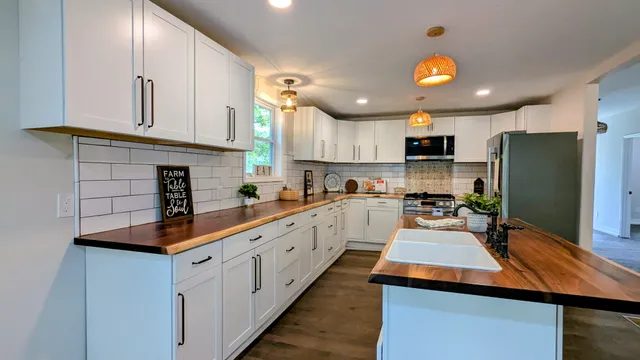 a kitchen with stainless steel appliances granite countertop a sink a stove and a refrigerator