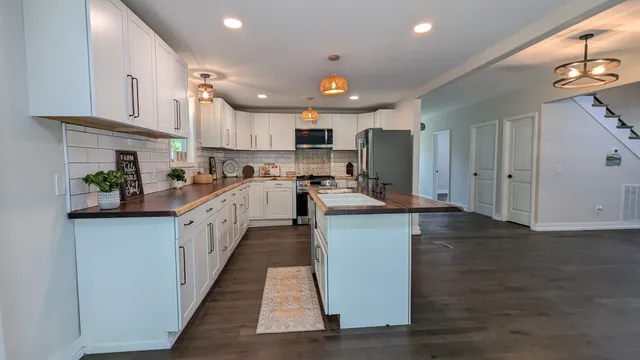 a kitchen with stainless steel appliances granite countertop a sink stove and refrigerator