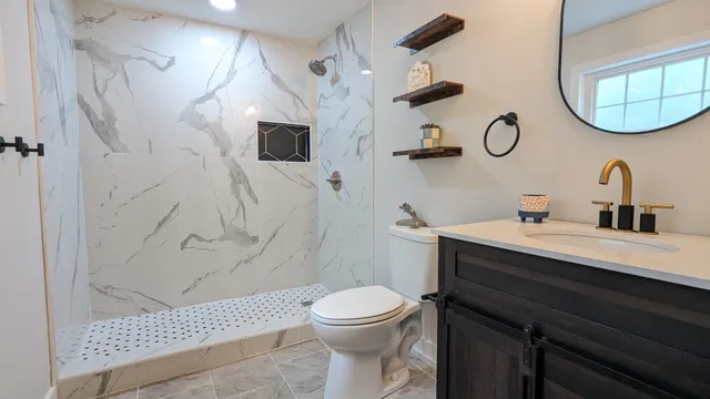 a bathroom with a sink a toilet and shower