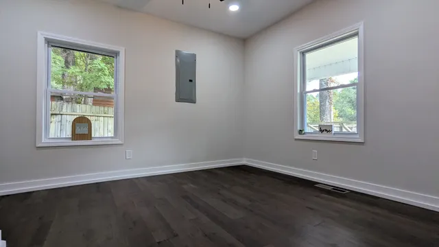 a view of a room that has wooden floor and windows in it