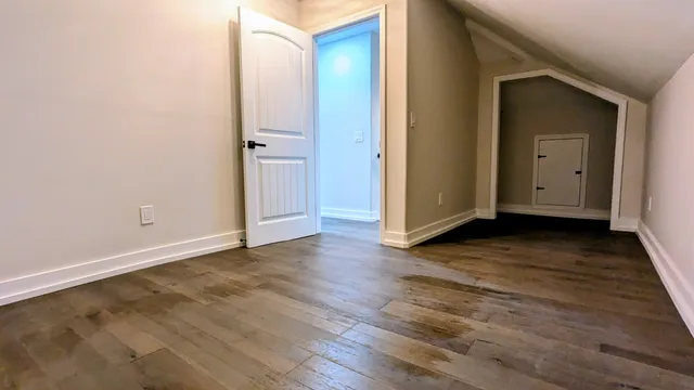 an empty room with wooden floor and closet