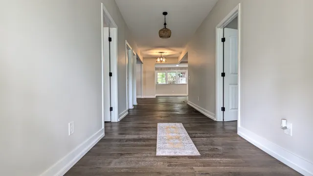 a view of a hallway with wooden floor and a window