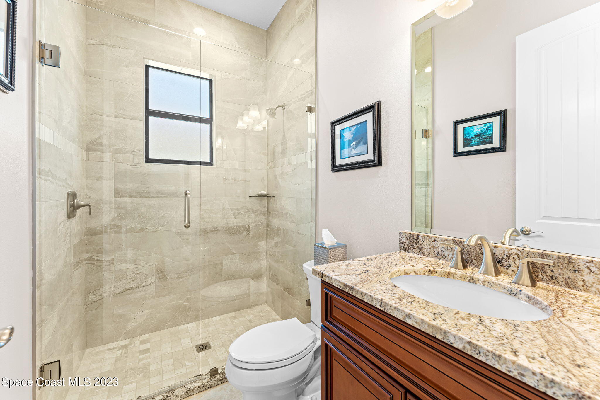 8429 Serrano Circle Melbourne, FL 32940 - Photo 12 of 28 a bathroom with a granite countertop sink a toilet and shower