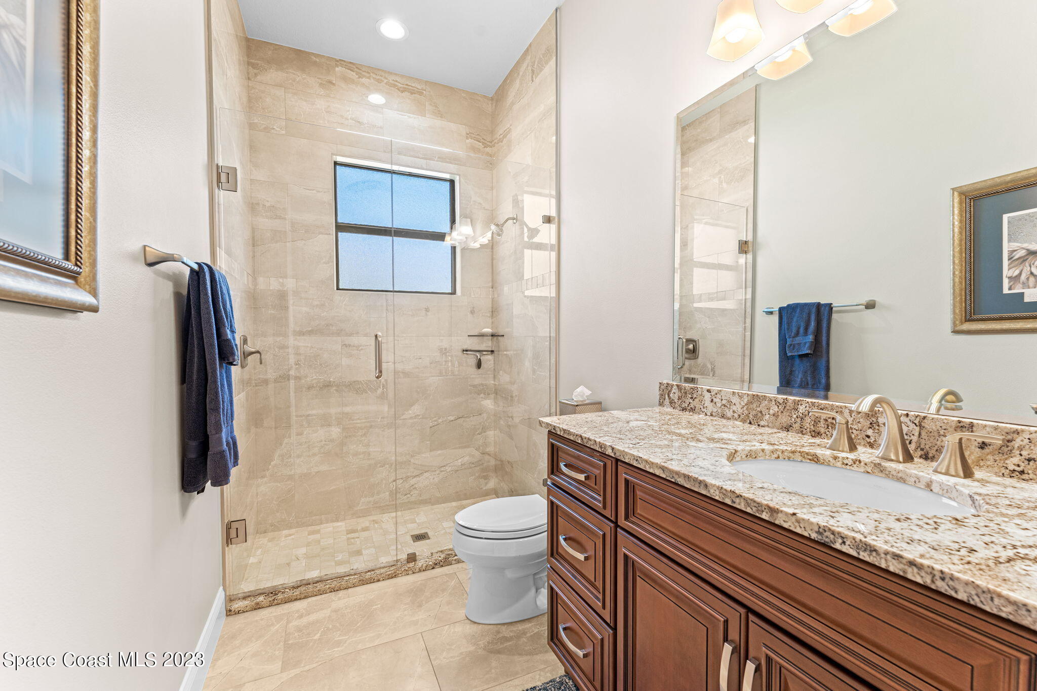 8429 Serrano Circle Melbourne, FL 32940 - Photo 14 of 28 a bathroom with a granite countertop toilet sink and mirror