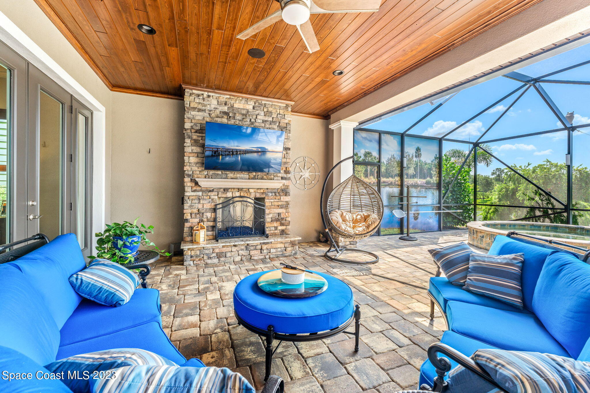 8429 Serrano Circle Melbourne, FL 32940 - Photo 18 of 28 a living room with furniture a chandelier and a floor to ceiling window