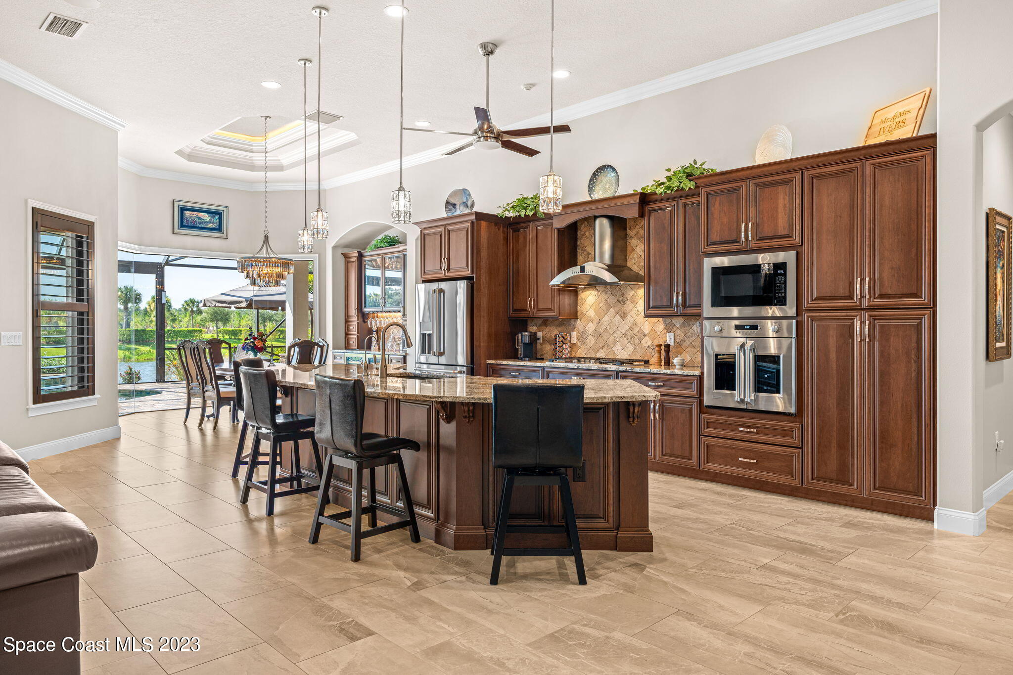 8429 Serrano Circle Melbourne, FL 32940 - Photo 4 of 28 a kitchen with stainless steel appliances granite countertop a table chairs and a refrigerator