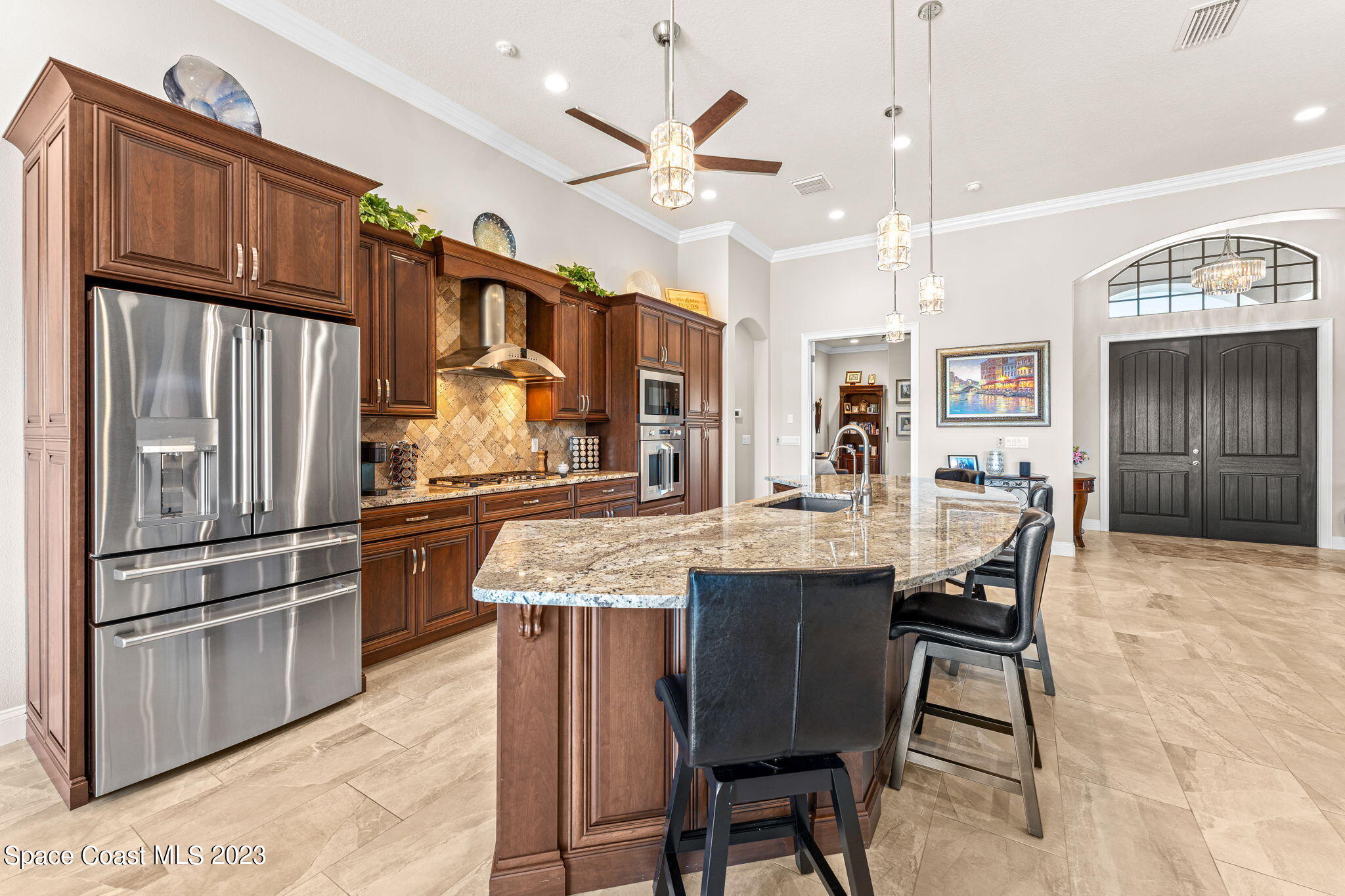 8429 Serrano Circle Melbourne, FL 32940 - Photo 5 of 28 a kitchen with stainless steel appliances kitchen island granite countertop a refrigerator a stove a sink a dining table and chairs with wooden floor