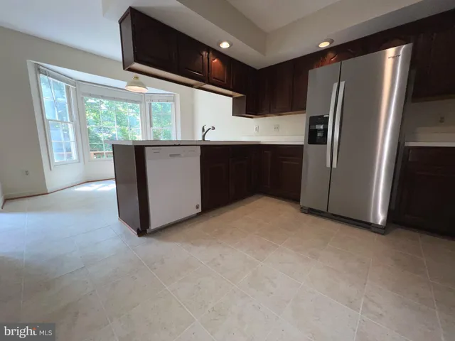 a kitchen with stainless steel appliances a refrigerator and wooden cabinets