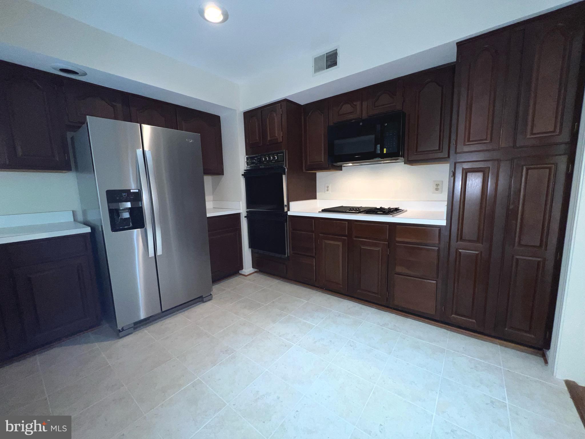 2104 Patty Lane Vienna, VA 22182 - Photo 8 of 19 a kitchen with stainless steel appliances a refrigerator and wooden cabinets