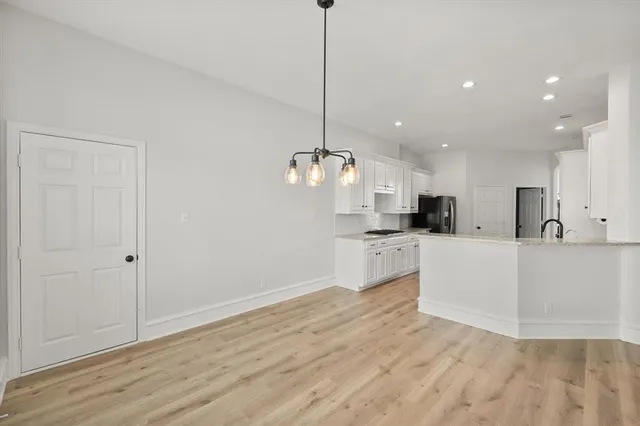 a view of kitchen with granite countertop cabinets and refrigerator