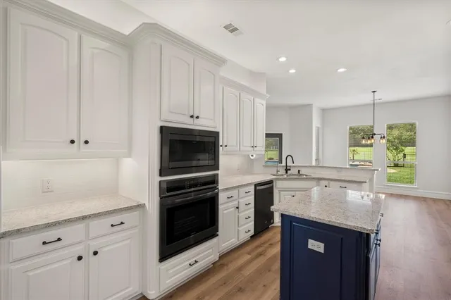 a kitchen with white cabinets and appliances
