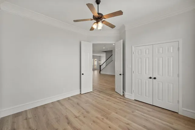 wooden floor in an empty room with a chandelier fan