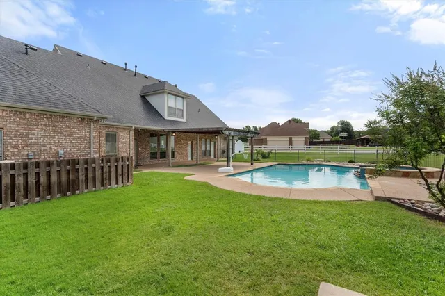 a view of a house with swimming pool and a yard