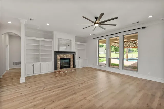 a view of an empty room with a window and fireplace