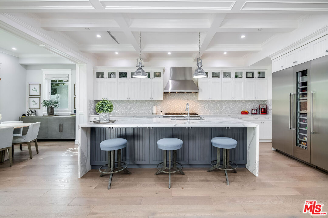14920 Addison Street Sherman Oaks, CA 91403 - Photo 15 of 52 a kitchen with granite countertop a table chairs stove a sink and a refrigerator