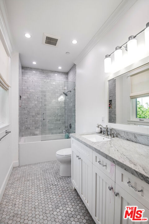 14920 Addison Street Sherman Oaks, CA 91403 - Photo 34 of 52 a bathroom with a granite countertop sink a toilet a mirror and bathtub