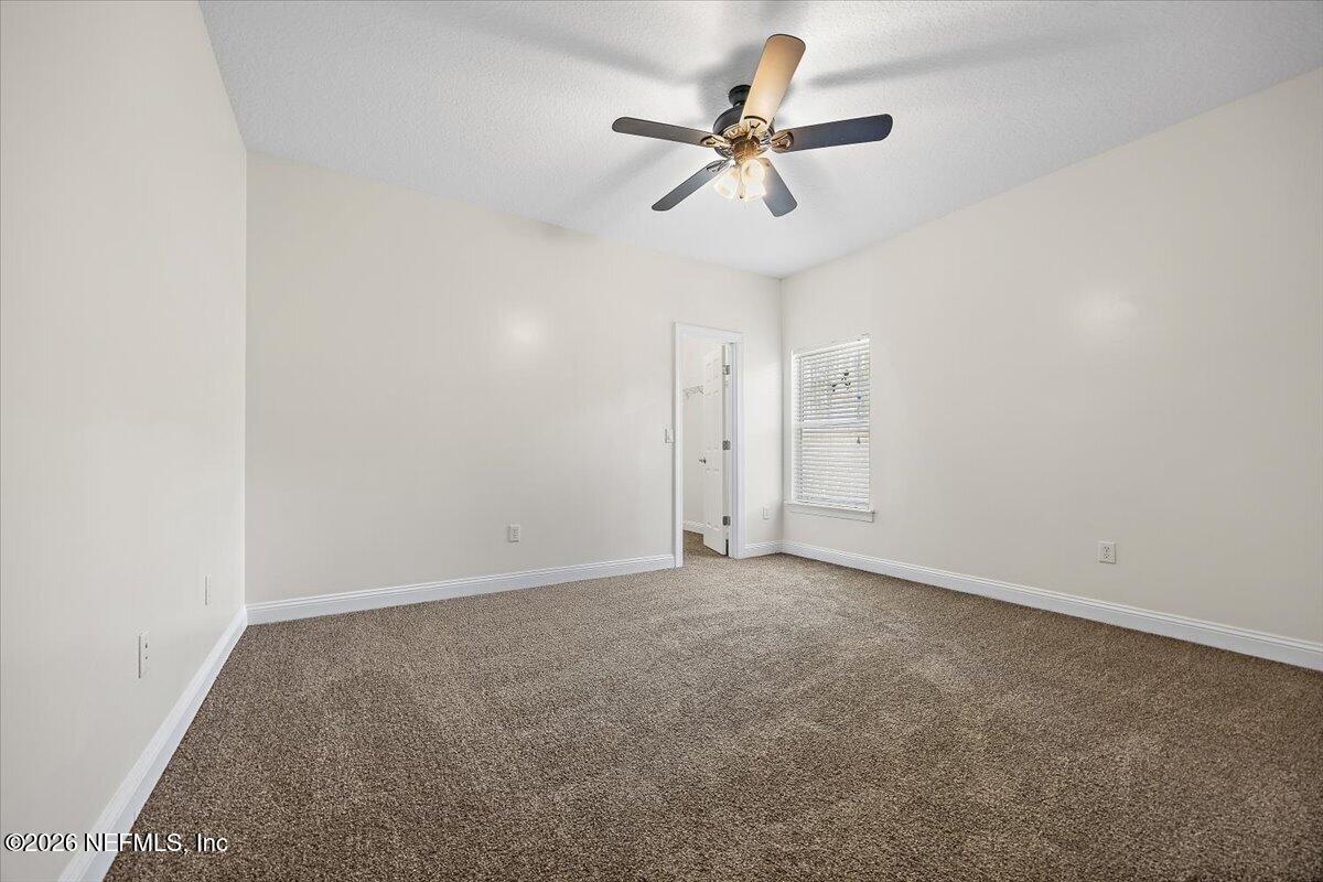 436 Chattan Way Fruit Cove, FL 32259 - Photo 21 of 41 an empty room with a chandelier fan and windows