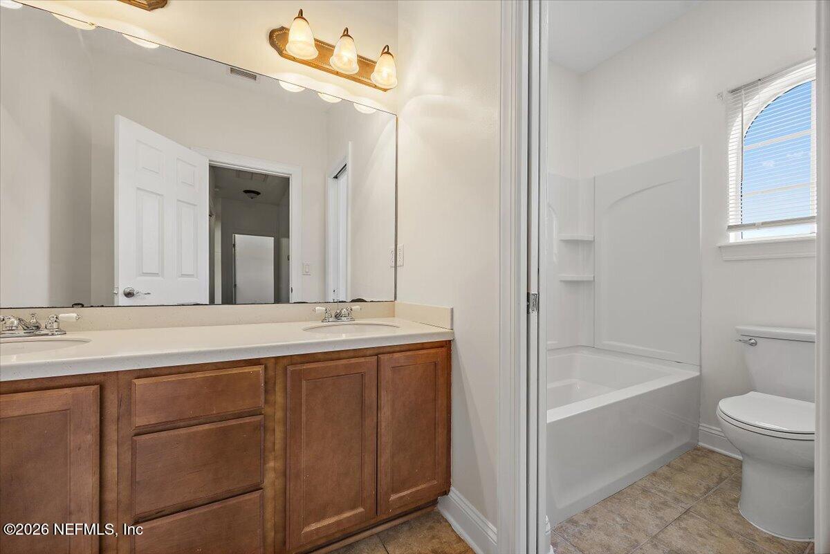 436 Chattan Way Fruit Cove, FL 32259 - Photo 26 of 41 a bathroom with a granite countertop sink a toilet mirror and bathtub