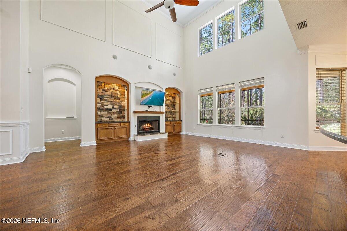 436 Chattan Way Fruit Cove, FL 32259 - Photo 9 of 41 an empty room with windows fireplace and wooden floor