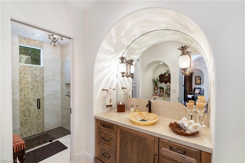 16727 Lucarno Way Naples, FL 34110 - Photo 12 of 36 a bathroom with a granite countertop sink a mirror and shower