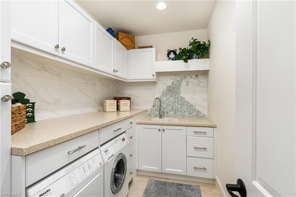 16727 Lucarno Way Naples, FL 34110 - Photo 14 of 36 a utility room with cabinets washer and dryer
