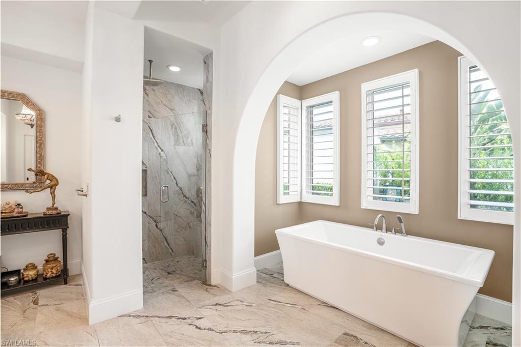 16727 Lucarno Way Naples, FL 34110 - Photo 16 of 36 a white bath tub sitting in a bathroom next to a window