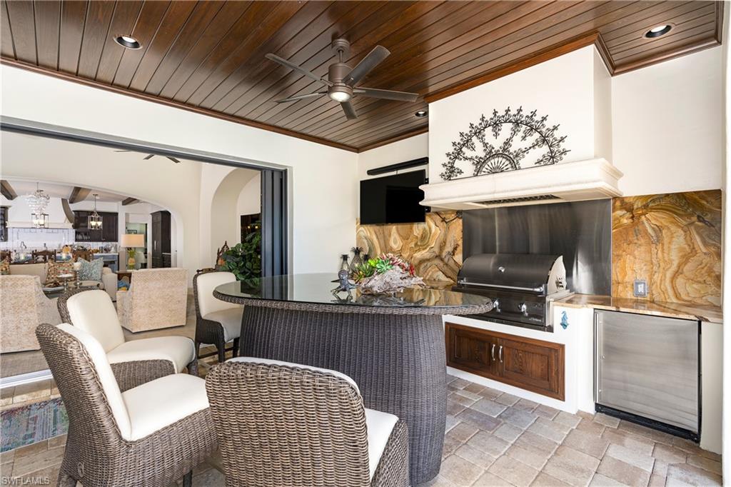 16727 Lucarno Way Naples, FL 34110 - Photo 23 of 48 a kitchen with stainless steel appliances kitchen island granite countertop a stove and a refrigerator