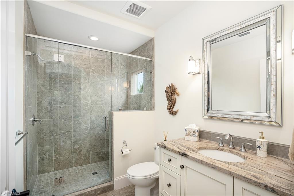 16727 Lucarno Way Naples, FL 34110 - Photo 26 of 36 a bathroom with a granite countertop sink toilet and shower