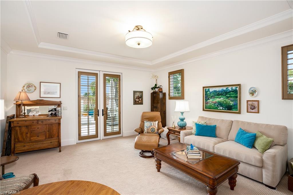 16727 Lucarno Way Naples, FL 34110 - Photo 32 of 48 a living room with furniture and a flat screen tv
