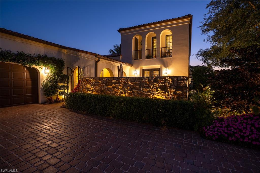 16727 Lucarno Way Naples, FL 34110 - Photo 42 of 48 View of front of house featuring a balcony, decorative driveway, an attached garage, stucco siding, and french doors