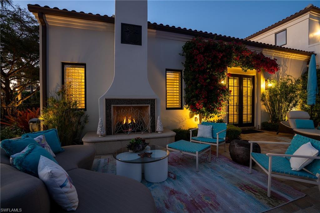 16727 Lucarno Way Naples, FL 34110 - Photo 46 of 48 a living room with furniture a fireplace and a potted plant
