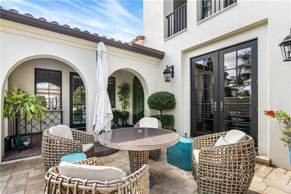 16727 Lucarno Way Naples, FL 34110 - Photo 5 of 36 a view of a patio with couches table and chairs and potted plants