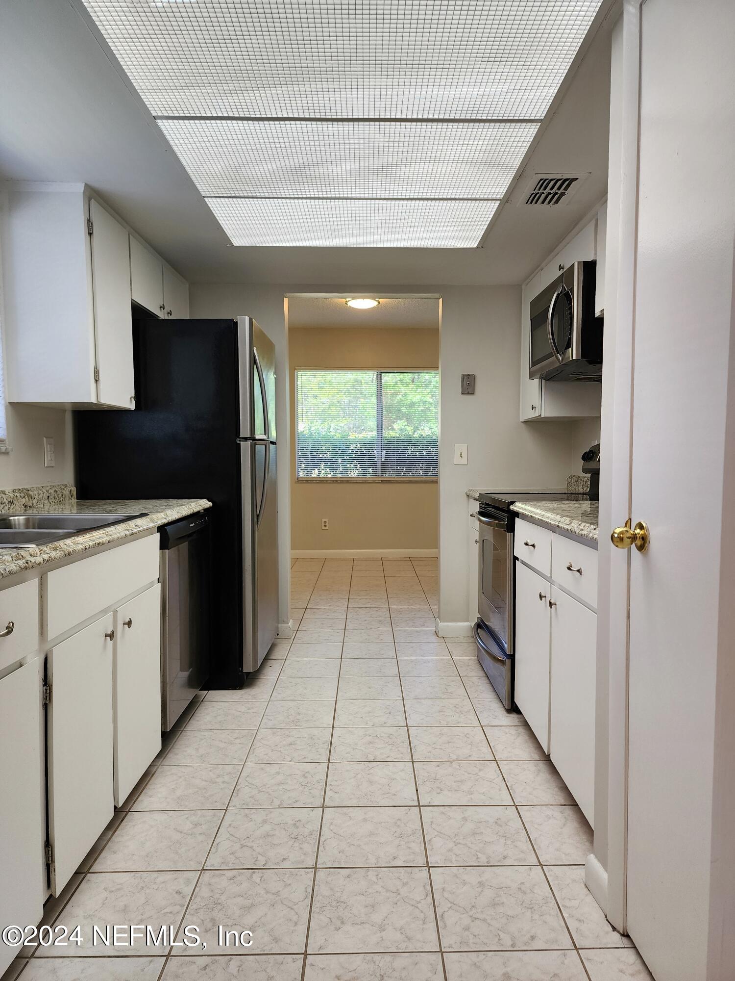 8423 Graybar Drive Jacksonville, FL 32221 - Photo 12 of 29 a kitchen with stainless steel appliances granite countertop a stove a sink and a refrigerator