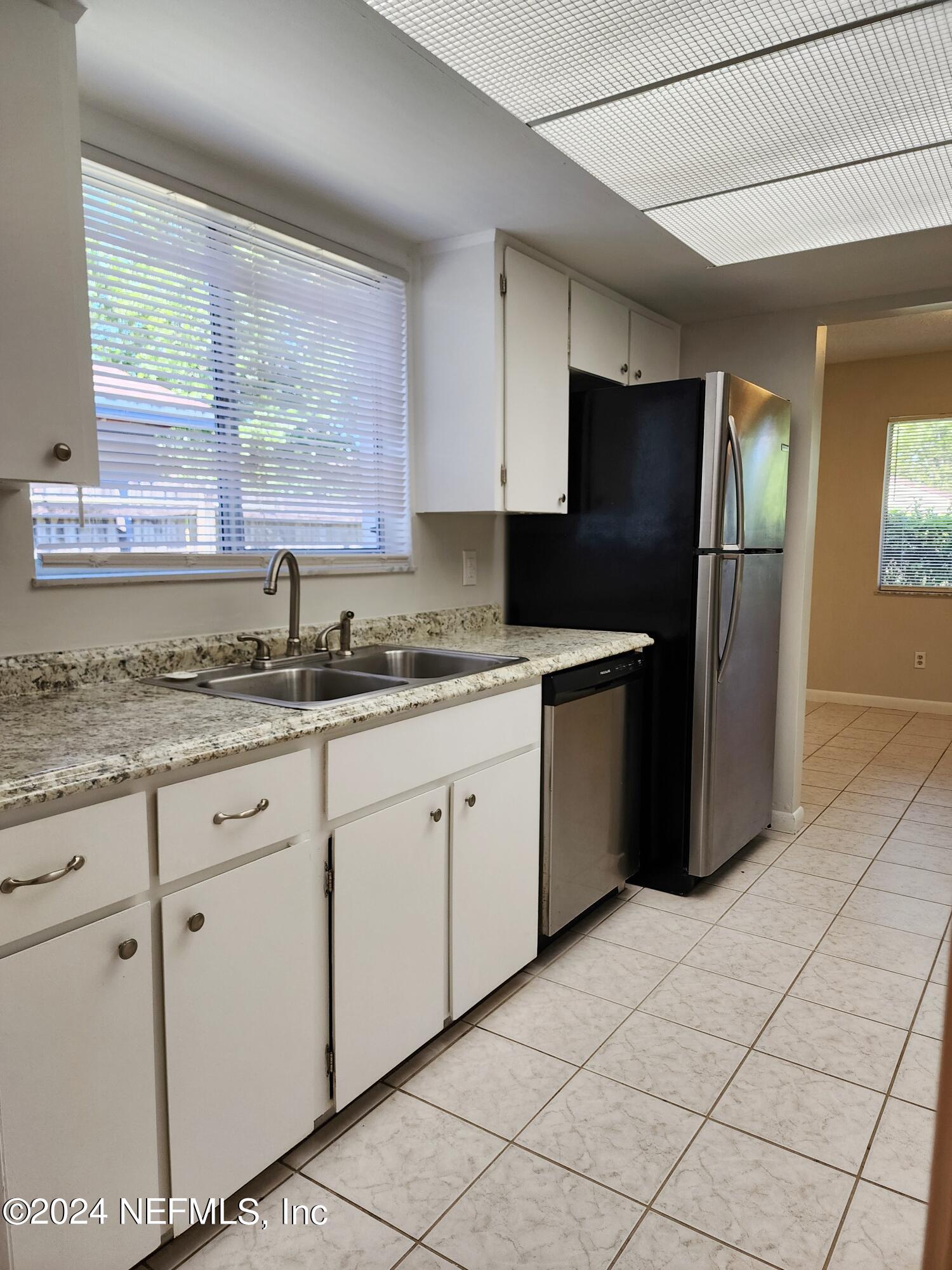 8423 Graybar Drive Jacksonville, FL 32221 - Photo 13 of 29 a kitchen with granite countertop a refrigerator sink and cabinets