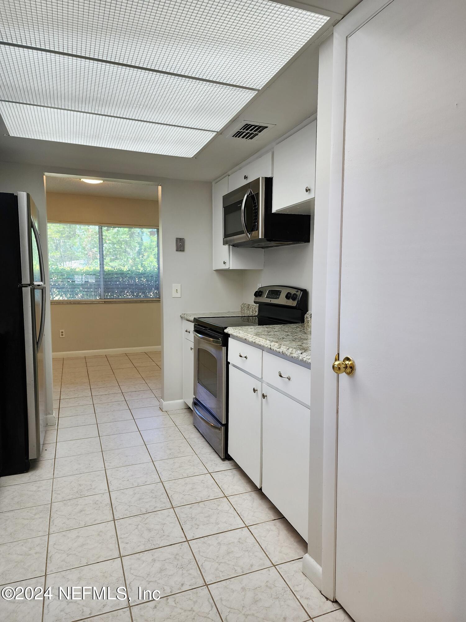 8423 Graybar Drive Jacksonville, FL 32221 - Photo 14 of 29 a kitchen with stainless steel appliances granite countertop a stove a sink and a refrigerator