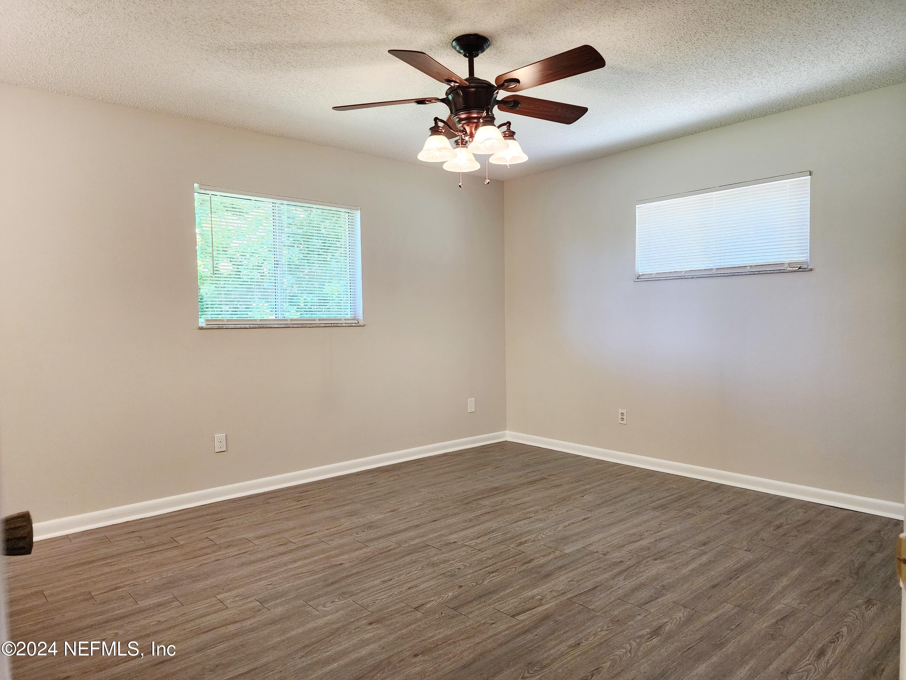 8423 Graybar Drive Jacksonville, FL 32221 - Photo 21 of 29 a view of an empty room with wooden floor