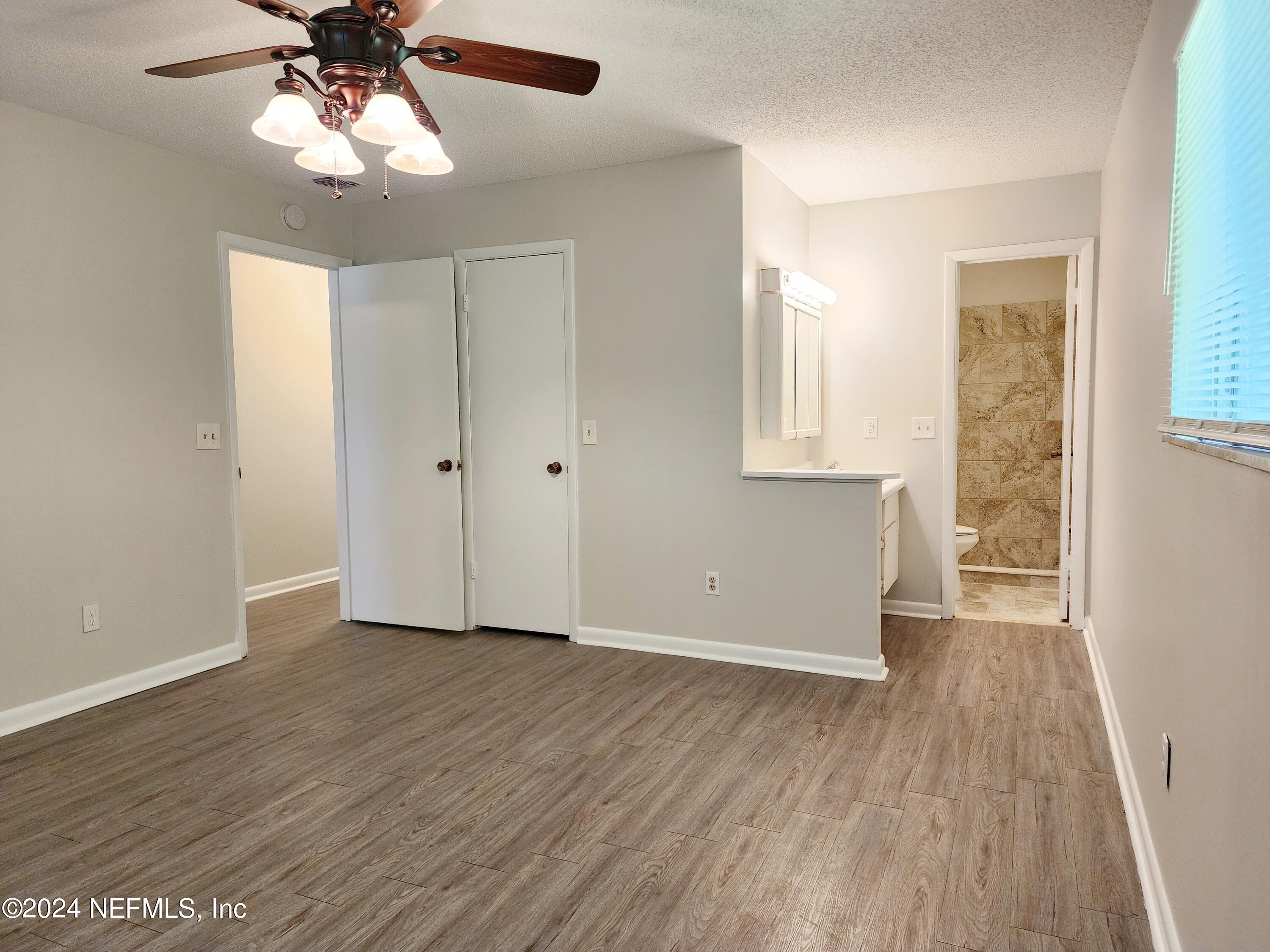 8423 Graybar Drive Jacksonville, FL 32221 - Photo 23 of 29 a view of an empty room with wooden floor and a window