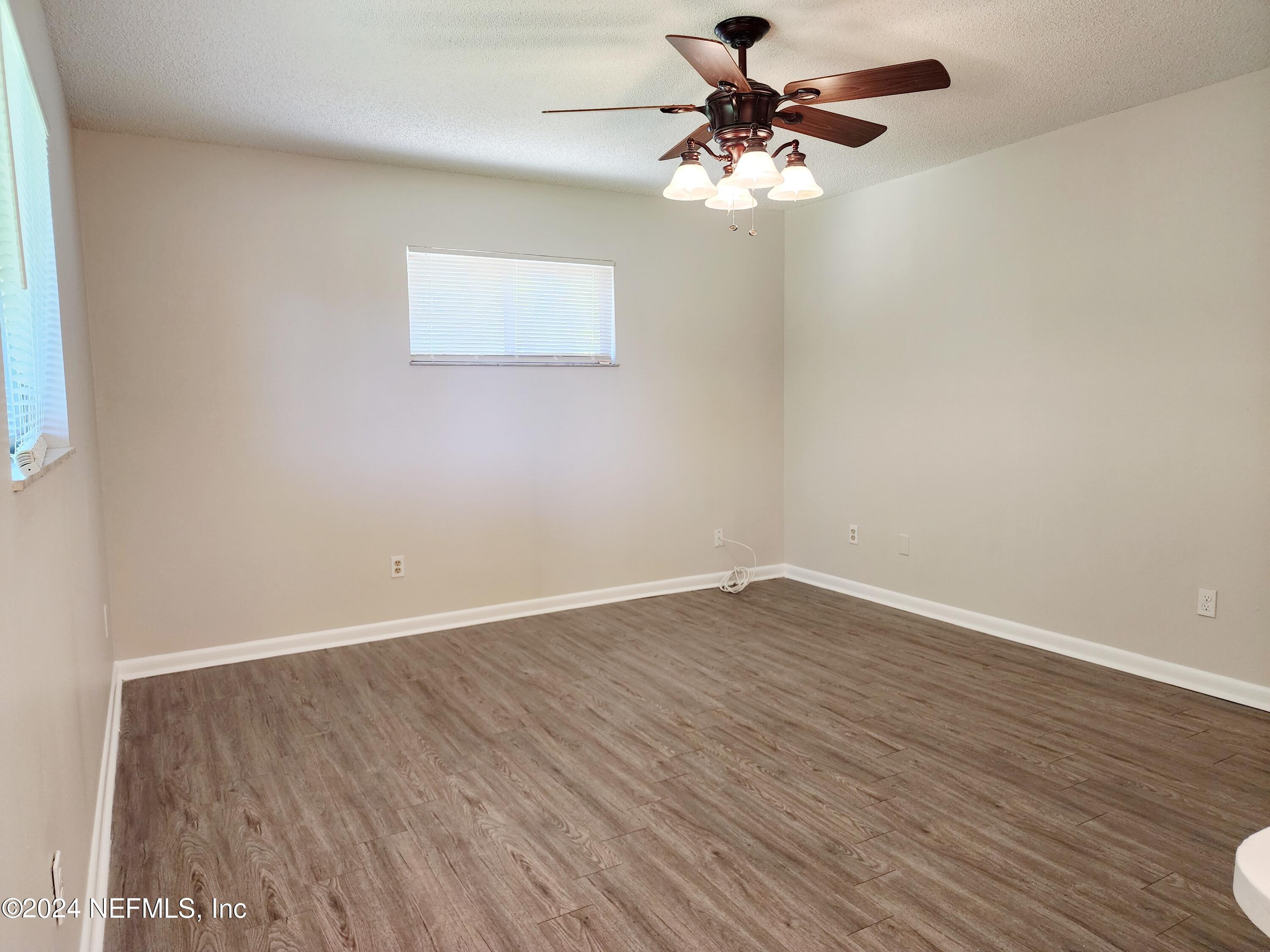 8423 Graybar Drive Jacksonville, FL 32221 - Photo 24 of 29 wooden floor in an empty room with a window