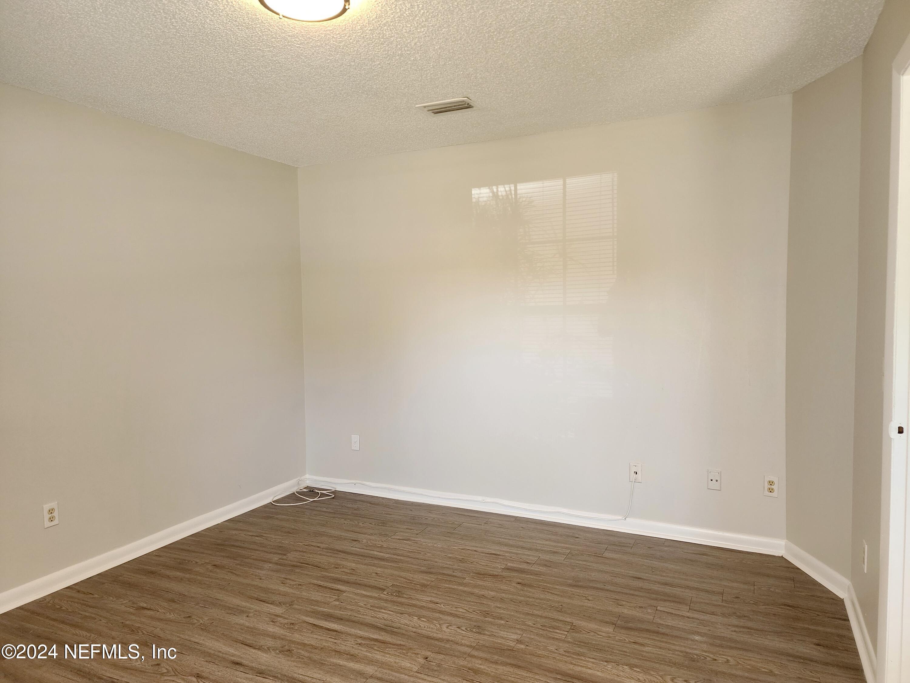8423 Graybar Drive Jacksonville, FL 32221 - Photo 5 of 29 a view of an empty room with wooden floor