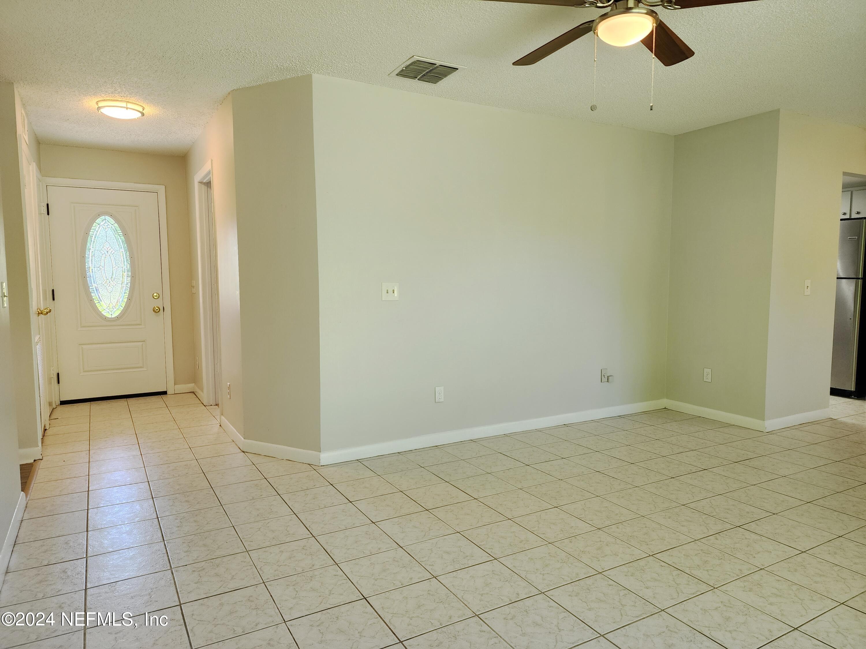8423 Graybar Drive Jacksonville, FL 32221 - Photo 7 of 29 an empty room with wooden floor and windows
